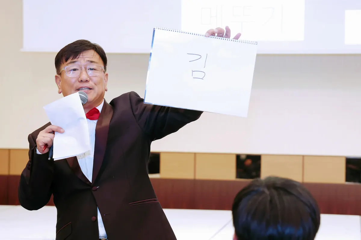무대에서 마이크를 들고 행사를 진행하는 MC 신용주